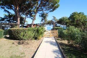 einen Gehweg mit einem Holzzaun und Bäumen in der Unterkunft Appartement 4 personnes vue mer résidence pierre et vacances à Pramousquier in Rayol-Canadel-sur-Mer
