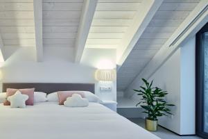 a bedroom with a bed with white sheets and pink pillows at Casa de la paz en el Valle de Tena in Sandiniés
