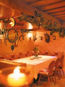 a dining room with a table with chairs and a candle at Hotel Lammwirt in Jerzens