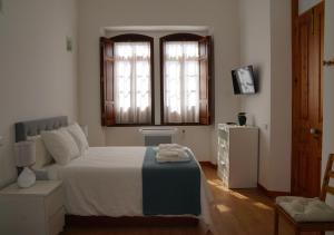 una camera da letto con un letto e due finestre di Casa de Marim AL a Olhão