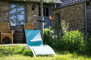 a blue chair in the yard of a house at Huize Mesch in Eijsden