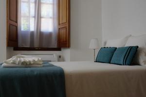 una camera da letto con un letto con cuscini blu e una finestra di Casa de Marim AL a Olhão