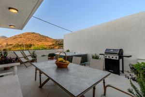 a table with a basket of fruit on a patio at Casa Kastella, private jacuzzi & BBQ facilities! in Angouselianá