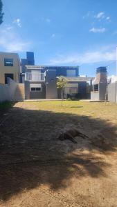 un perro tirado en el suelo frente a un edificio en Casa en Sauce Grande - Calvario, en Balneario Sauce Grande