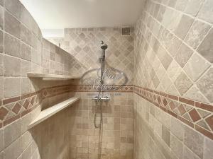 y baño alicatado con ducha y manguera. en Appartement plain-pied avec terrasse proche de la plage du Canadel, en Rayol-Canadel-sur-Mer