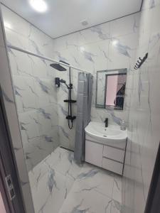 a white bathroom with a sink and a mirror at Tsaghkadzor Inn Guest House in Tsaghkadzor
