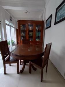a dining room with a wooden table and chairs at Kadipiro Homestay in Ngabean