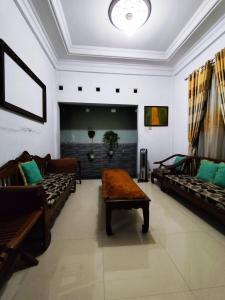 a living room with couches and a table in a room at Kadipiro Homestay in Ngabean