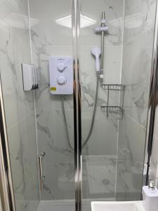 a bathroom with a shower with a glass door at Luxury Studio in Victoria, 7 minutes walk to Victoria Station, Room 5 in London