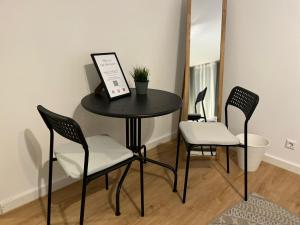 a black table with two chairs and a mirror at Süße Marie Durlach 12 in Karlsruhe
