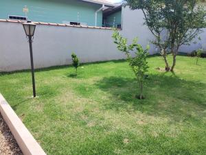 a yard with two trees and a street light at Casinha inteligente in Botucatu