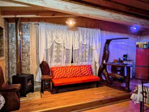 a living room with an orange couch and a desk at Cabañas Lago Llanquihue in Llanquihue