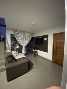 ein Wohnzimmer mit einer Couch und einem Fenster in der Unterkunft Casa Vista Mar in Governador Celso Ramos