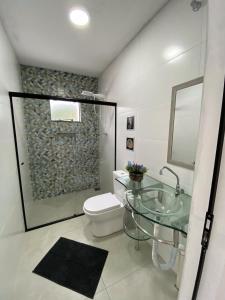 ein Badezimmer mit einem Glaswaschbecken und einem WC in der Unterkunft Casa Vista Mar in Governador Celso Ramos + 66 Fotos