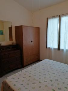 a bedroom with a bed and a dresser and a mirror at Stella Marina in Tertenìa