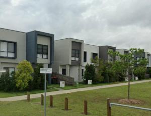 a street sign in front of a building at Modern Elegance Near Lakes Train Parks and Beaches in North Lakes