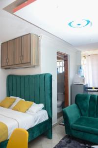RuiruにあるCozy Cabin Apartmentのベッドルーム(緑のベッド1台、緑の椅子付)