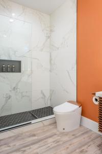a bathroom with a toilet and a glass shower at Spacious 4BR, Pool, Jacuzzi, Pickleball, Sauna, Cold Plunge in Desert Hot Springs