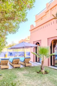 a patio with an umbrella and chairs and a pool at Luxury Villa with Pool, Garden & Gated Security in Marrakech