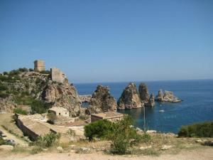 an island with a castle on top of the ocean at Apartments Scopello Inside in Scopello