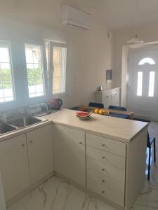 a kitchen with white cabinets and a counter top at Lemon tree Gr in Xylokastro +14 photos