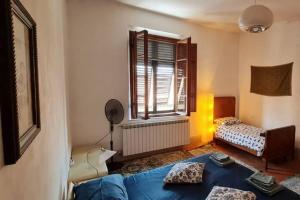 une chambre avec un lit bleu et une fenêtre dans l'établissement Casa e Risorgimento, à Pise