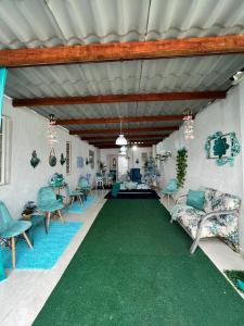 - un salon doté d'une moquette et de chaises vertes dans l'établissement Mansão pé na areia, à Itanhaém