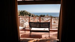 a chair sitting on a balcony looking out of a window at Taormina Palazzo di Ferro in Taormina