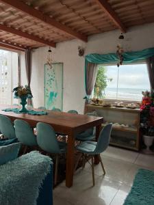 une salle à manger avec une table et des chaises en bois dans l'établissement Mansão pé na areia, à Itanhaém