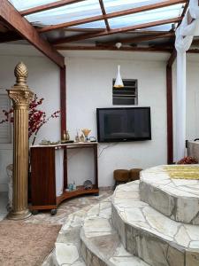 un salon avec une télévision à écran plat sur un mur dans l'établissement Mansão pé na areia, à Itanhaém 15 autres photos