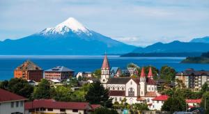 a city with a snow covered mountain in the background at Cabañas Lago Llanquihue in Llanquihue