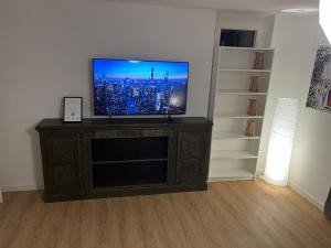 a flat screen tv sitting on top of a wooden entertainment center at Süße Marie Durlach 13 in Karlsruhe