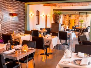un restaurante con mesas y sillas en una habitación en Slapen bij Scherp, en Middelburg