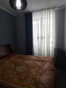 a bedroom with a large bed and a window at Sunny Valley apartment in Bakuriani