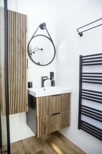 a bathroom with a sink and a clock on the wall at Domki na Cieńkowie in Wisła