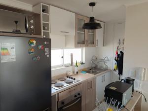 a small kitchen with a refrigerator and a sink at Los Molles apartment in Los Molles +4 photos
