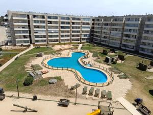 a large building with a swimming pool in front of a building at Los Molles apartment in Los Molles