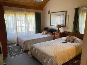 een slaapkamer met 2 bedden in een kamer met ramen bij Hermosa casa de campo in Talca