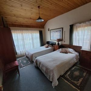 een slaapkamer met twee bedden en een houten plafond bij Hermosa casa de campo in Talca