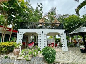 a white house with a balcony on top of it at Ban Suan Suree Resort in Ban Thung Yao