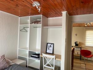 a bedroom with white shelves and a red chair at Golondrina El Tabo in El Tabo +5 photos