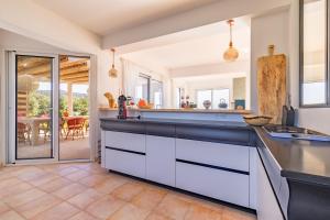 una cucina con armadi bianchi e una sala da pranzo di Villa La Ronde des Soleils a Coti-Chiavari