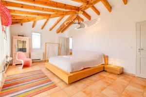 una camera da letto con un letto e una sedia di Villa La Ronde des Soleils a Coti-Chiavari Altre 28 foto