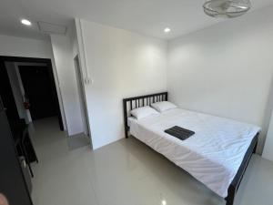 a white bedroom with a bed with white sheets and pillows at Patong Easy life 5 in Patong Beach