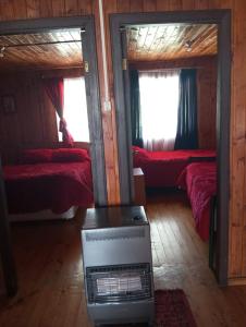 ein Zimmer mit zwei Betten und einer Klimaanlage in der Unterkunft Cabaña Punta Diamante in Castro + 5 Fotos