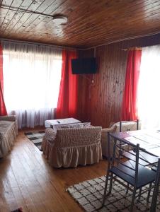 ein Zimmer mit zwei Betten, einem Tisch und Vorhängen in der Unterkunft Cabaña Punta Diamante in Castro