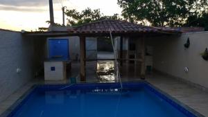 a swimming pool with an umbrella next to a house at Recanto Rocha in Nova Viçosa