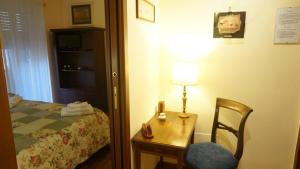 ローマにあるCasa Loryのベッド、テーブル、ランプが備わるお部屋