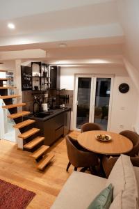 uma cozinha com uma escada em espiral e uma mesa e cadeiras em Zlatar mountain retreat em Nova Varoš