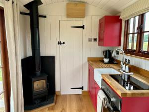 a kitchen with a wood stove in the middle at The Hut at Blackberry Barn in Long Itchington